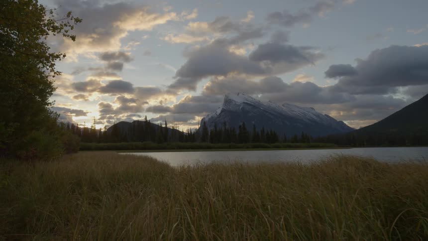 Grass leads to a lake at sunset