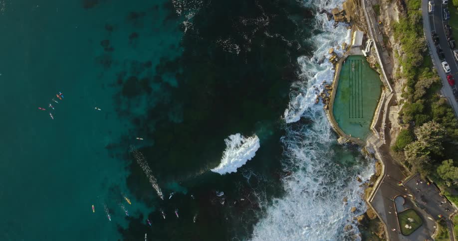 Aerial view of boats sailing off the coast and ocean pool