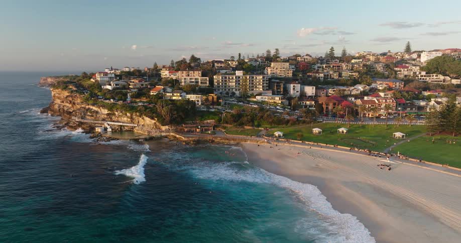 An aerial view of an urban city next to a beautiful turquoise blue beach
