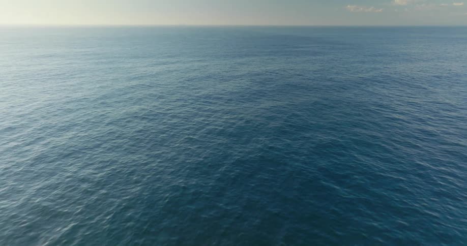 Sunlight shines on the water as it ripples and waves under a cloudy sky