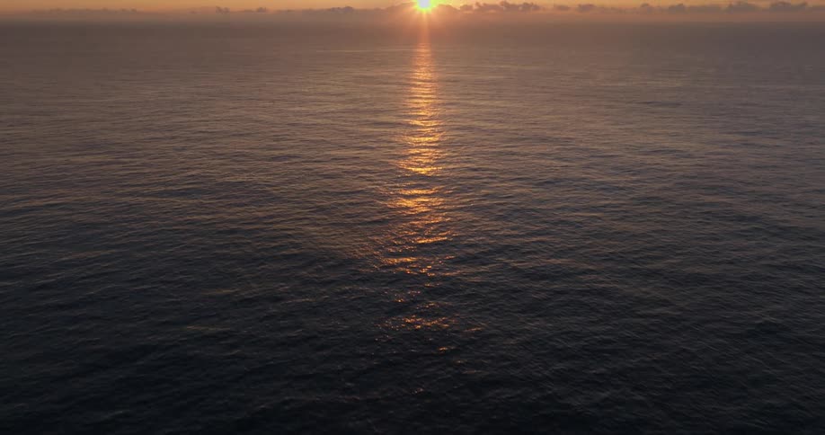 The open sea is shown with the sun setting behind it