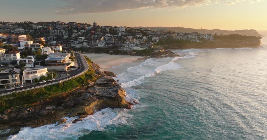 An aerial view of an urban city by the beach at the end of the day