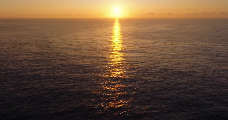 The sun is rising over the ocean