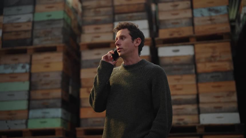 A man talking on the phone in a warehouse