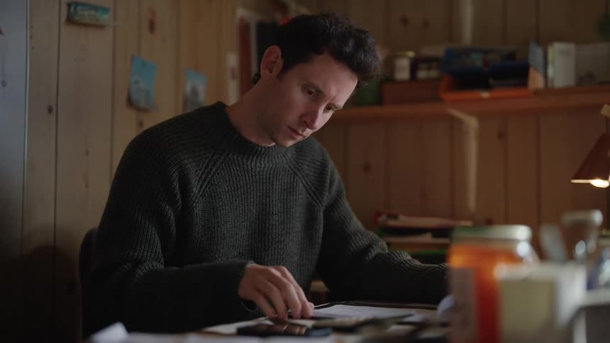 A man uses a calculator while reviewing documents at his desk