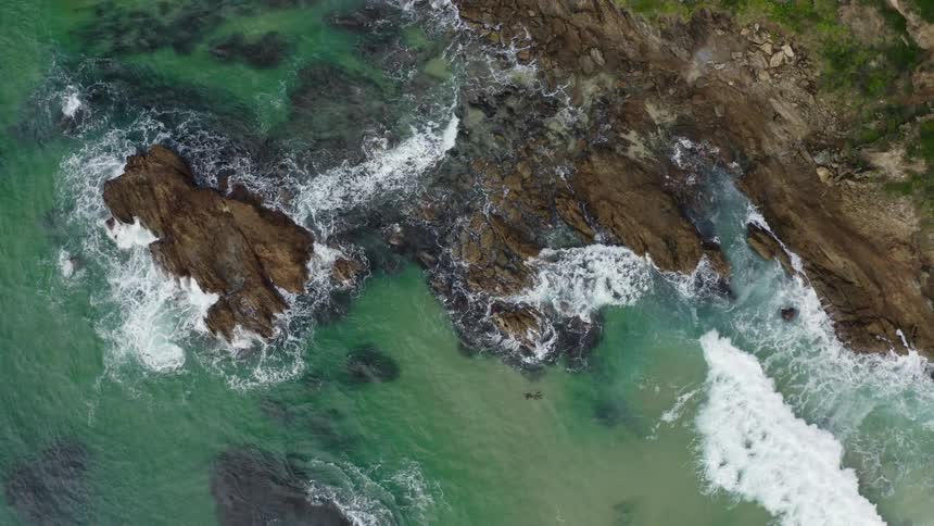 Aerial of a desert island with a rocky coast and blue waters