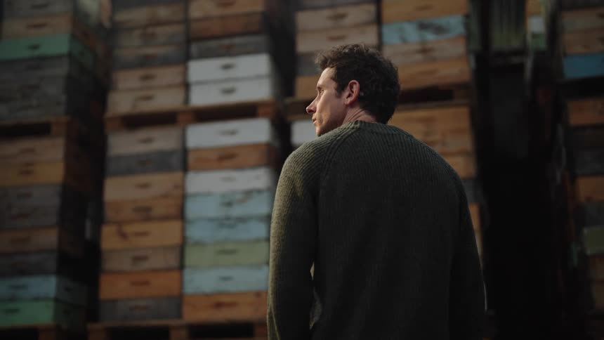 A man standing and staring at series of boxes stacked on each other