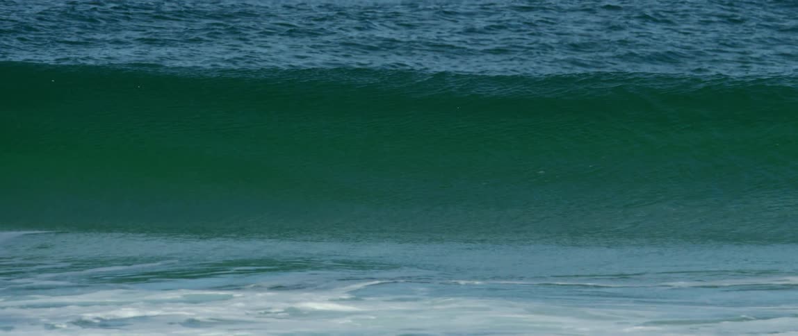 The ocean is unsettled as it gets hit by a huge wave