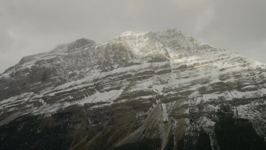 Clouds floating above snow covered cliffs