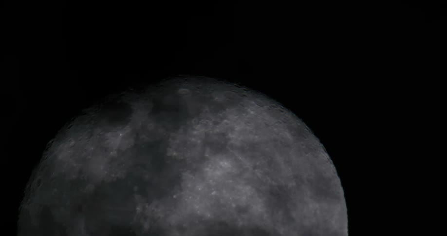 A closeup of a full moon with a cloudy sky