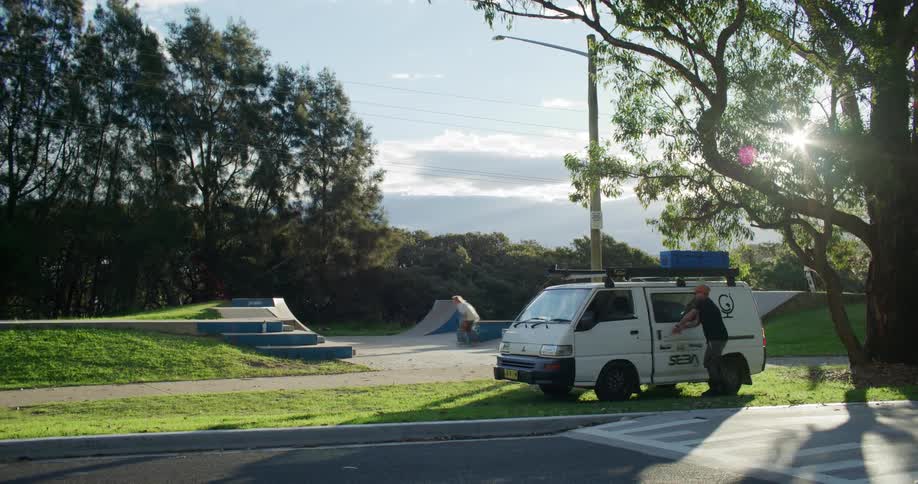 People skateboard on a ramp during the day