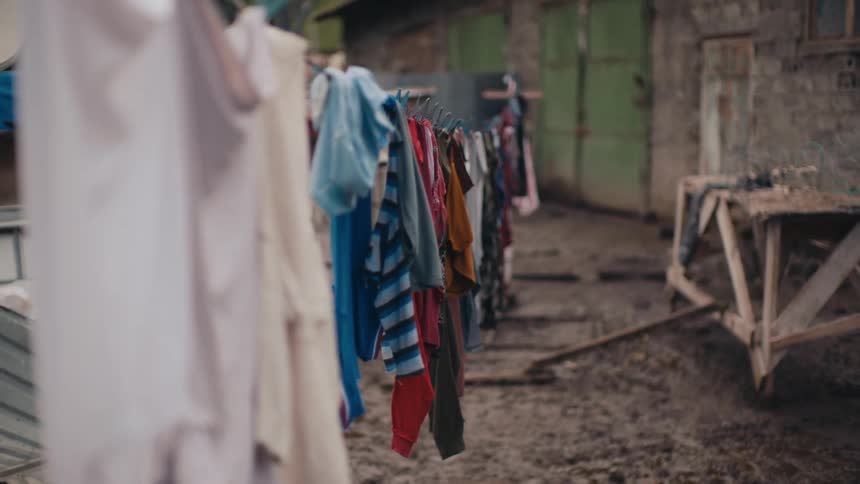 A view of an outdoor clothesline with clothes drying in a thirdworld neighborhood
