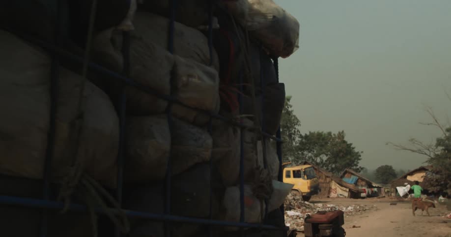 A cart with several stacked bags being taken in a precarious environment