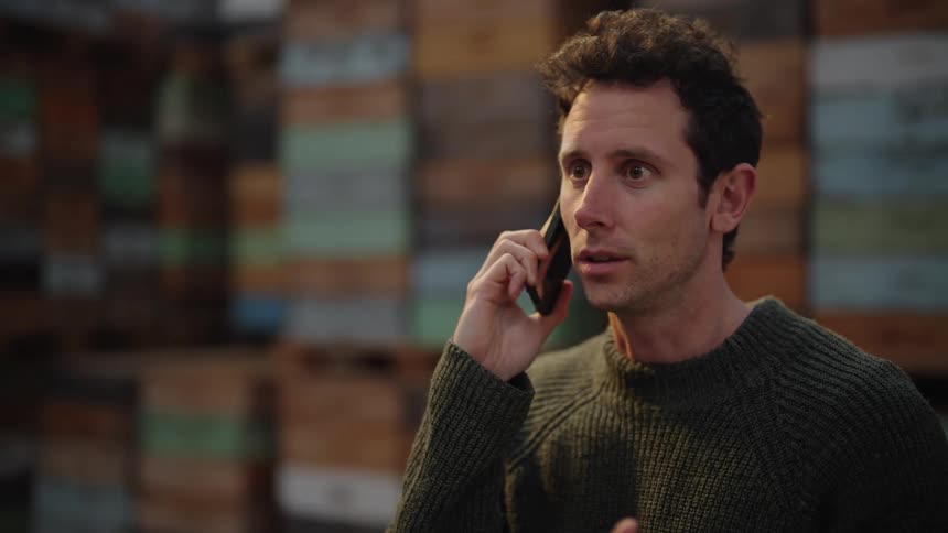 A portrait of a man talking on the phone and gesturing with his hands