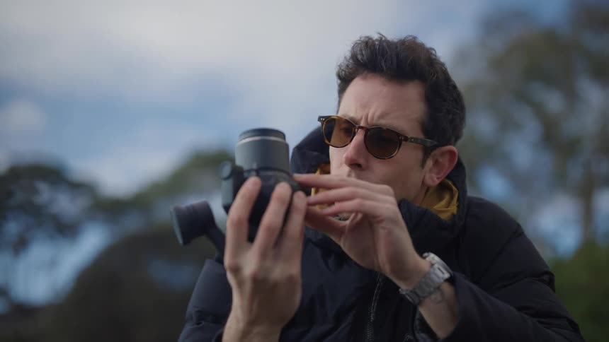 A man carefully examines a camera in his hands