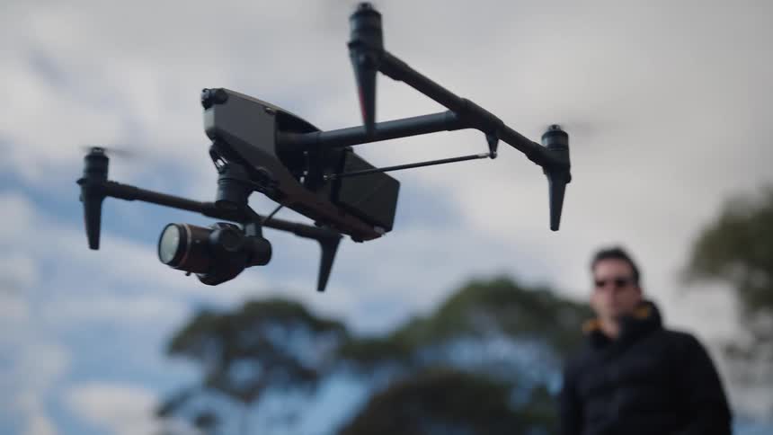 A man uses the drone lifting it up into the sky