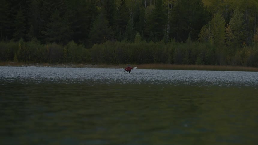 A person is rowing in their canoe in the water