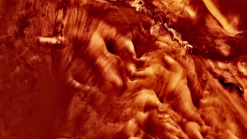 A red and yellow liquid is moving in two directions as if it is melting