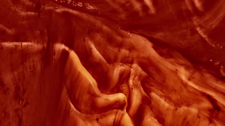 Orange mixture forms folds while flowing