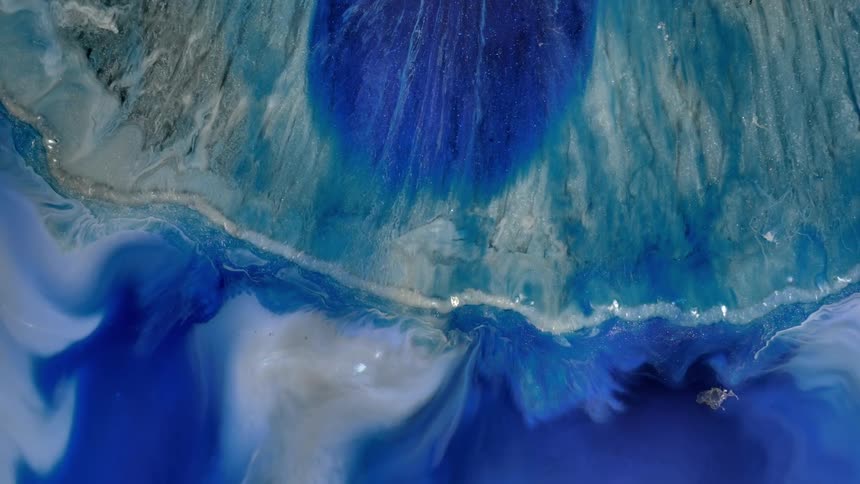 Liquid flows against base of blue and white textured surface