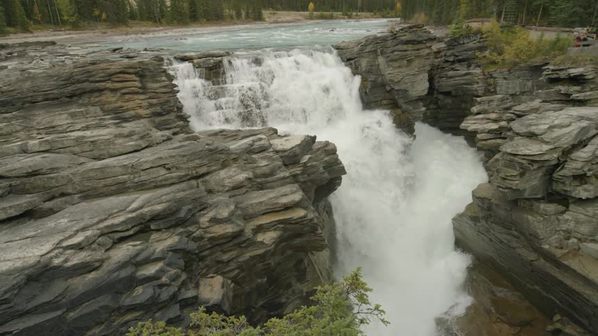 The waterfall is surrounded by trees and rocks