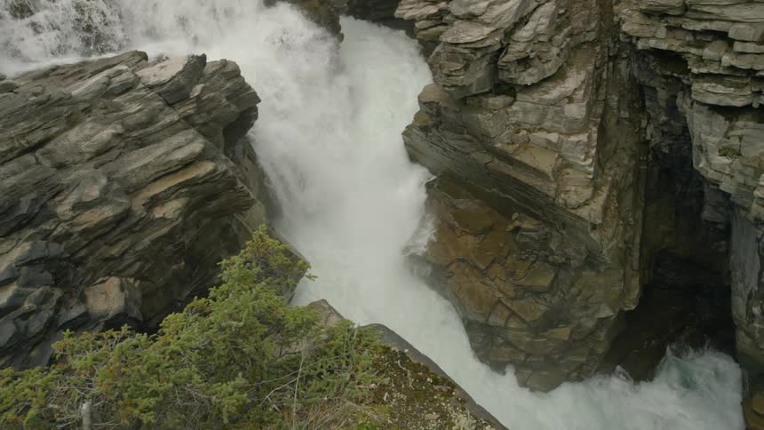 A waterfall is pouring water down the canyon below