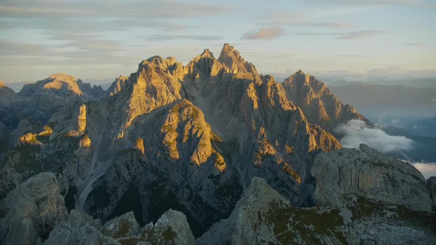 Mountains in shadow sit across valley from mountains highlighted by sun