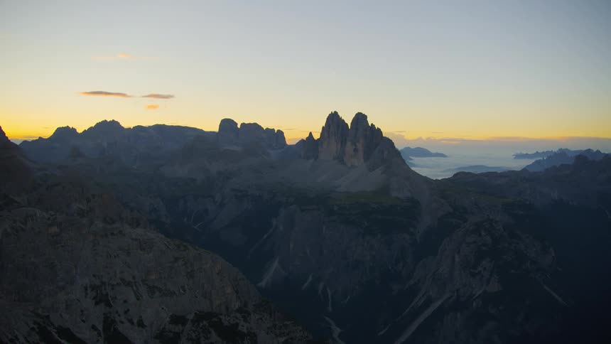 Aerial view of mountains and cliffs above the cloud level at sunrise