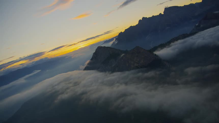 Aerial of horizon with clouds and mountains at sunset