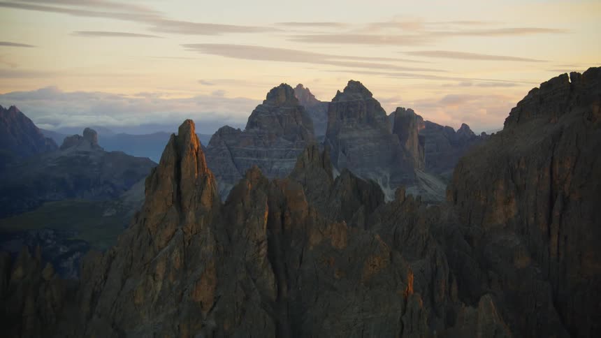 An aerial view of a mountain range and cliffs during a sunrise