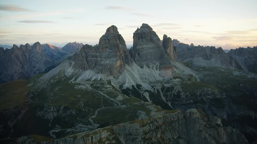 Aerial of a mountain with high and rocky peaks at sunset