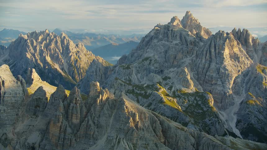 An aerial view of a rocky mountain range with geological formations and peaks