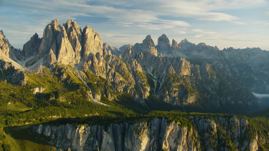 A region with many high mountains covered in sunlight and grass