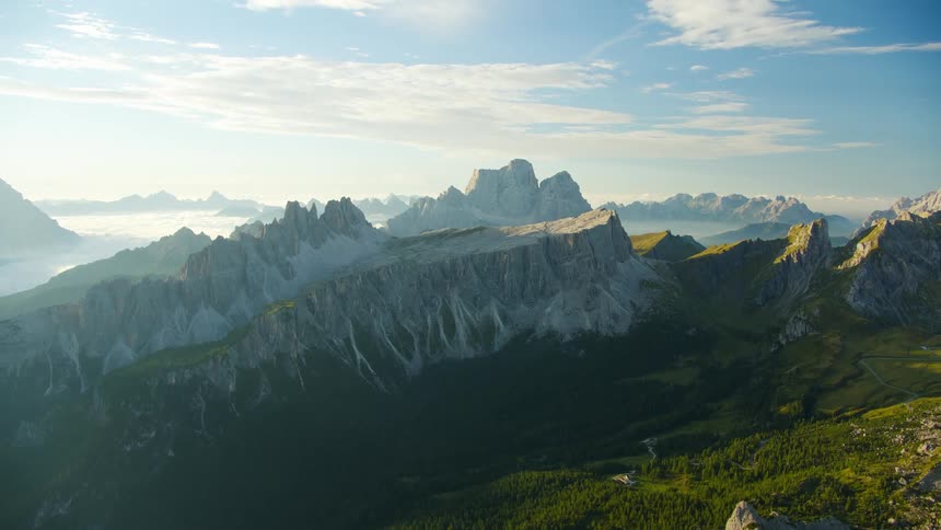 Aerial of mountains surrounded by grass at midday