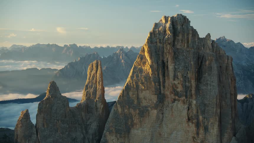 On a clear sunny day the sun shine on the tall mountain with rough pointing edge at the top
