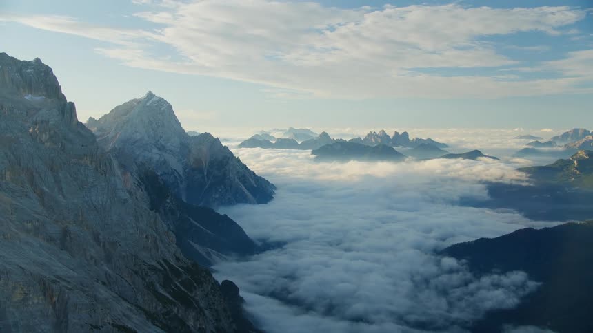 A view of a mountain range above the cloud level during a sunrise