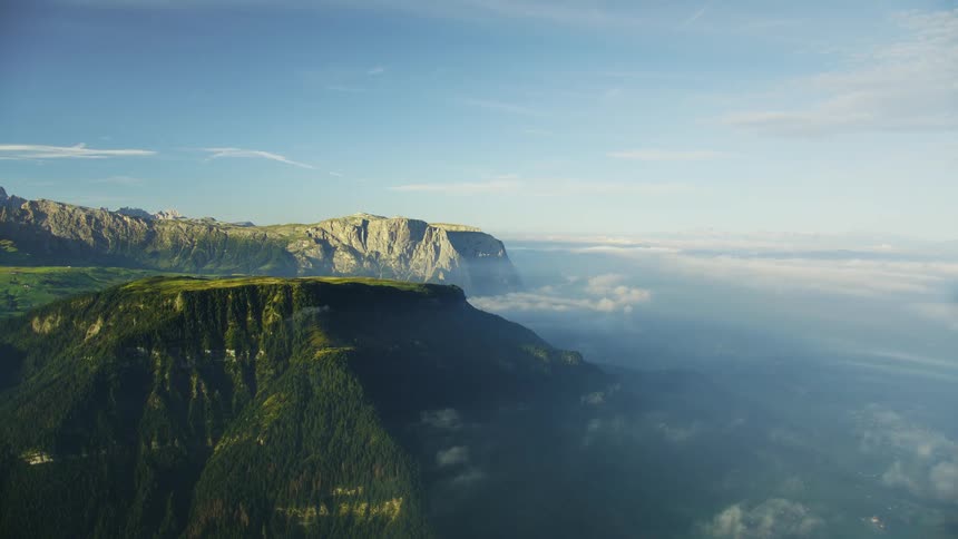 The mountain is covered in green vegetation with mist surrounding it
