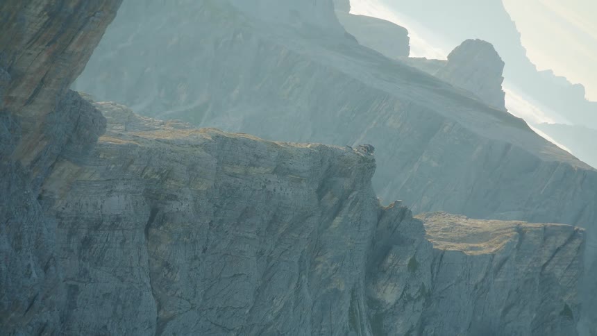 A mountain range with cliffs above the cloud level