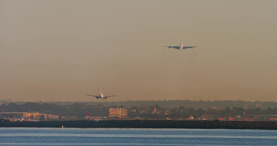 Two airplanes with one taking off and the other landing