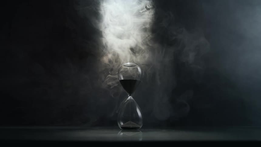 Vapor circulates above hourglass containing dark sand