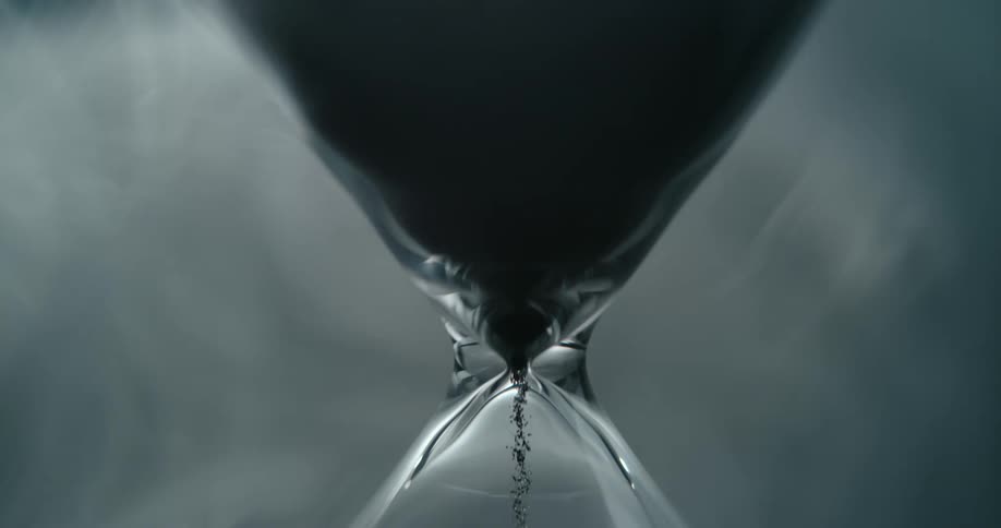 The sand is slowly pouring through the hourglass