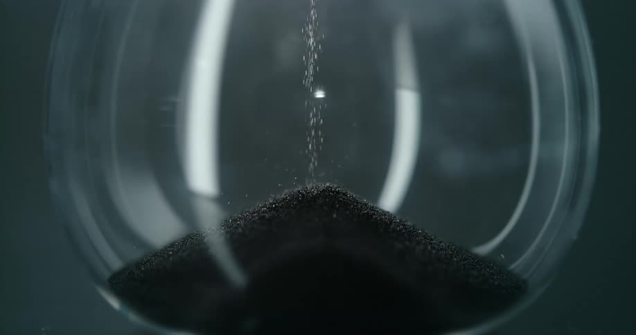 An hourglass with grains of sand falling from the top