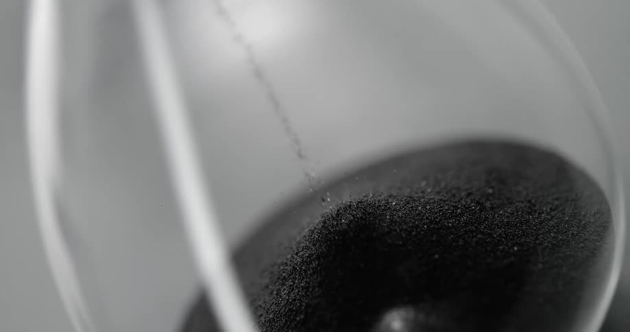 Sand dripping down in an hourglass