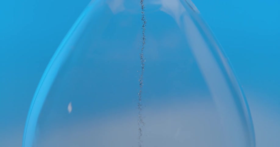 An hourglass with grains of sand falling from the top