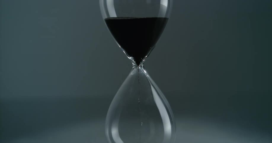 Sand flows through the center of an hourglass