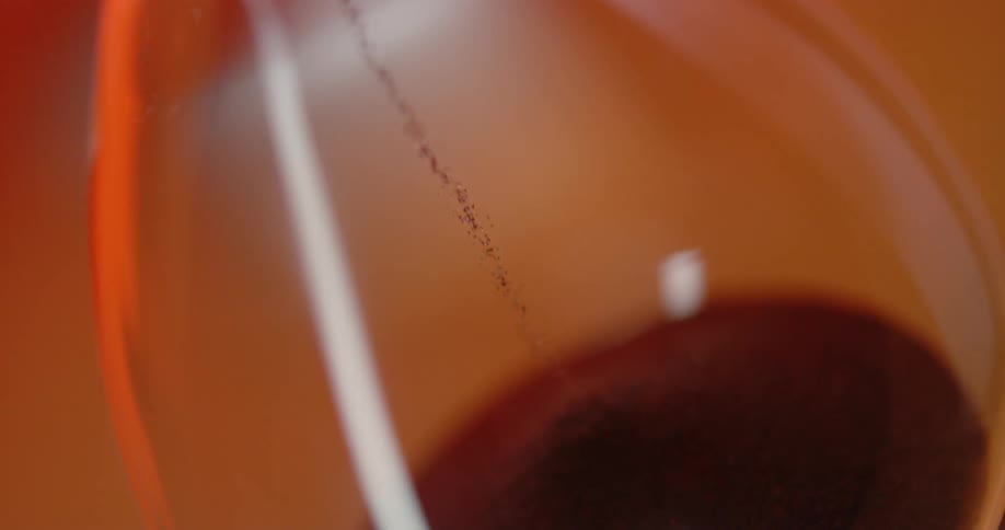 The sand slowly falls in the hourglass