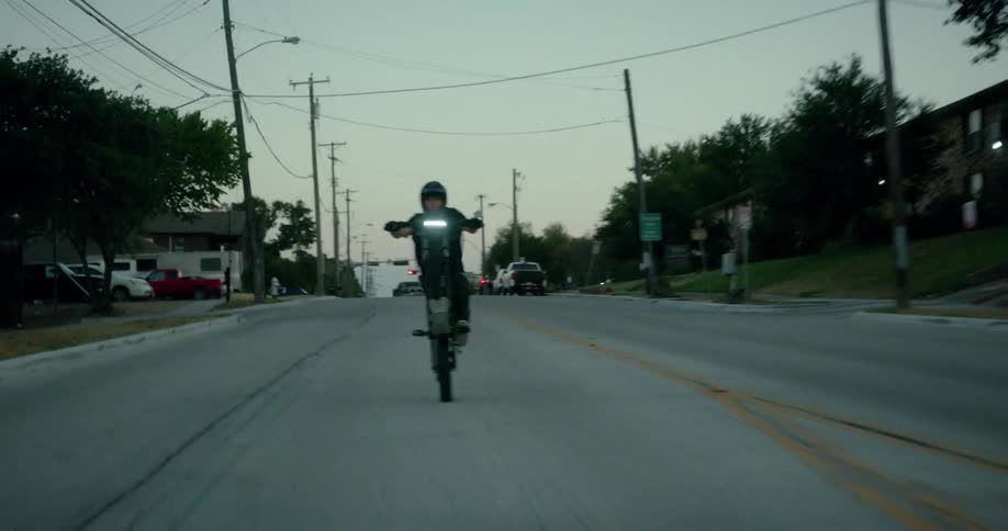 Man starting his motorcycle on the road at dawn