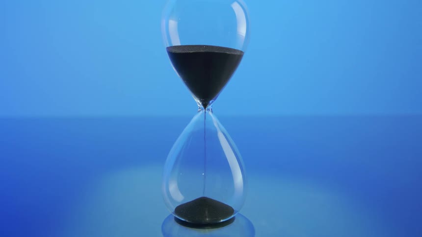 The hour glass is pouring sand down