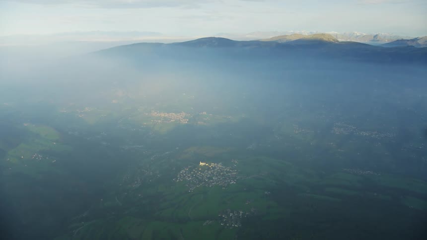 An aerial view of a natural landscape with plains and a mountain range