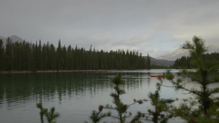 A person is rowing in a canoe in the lake